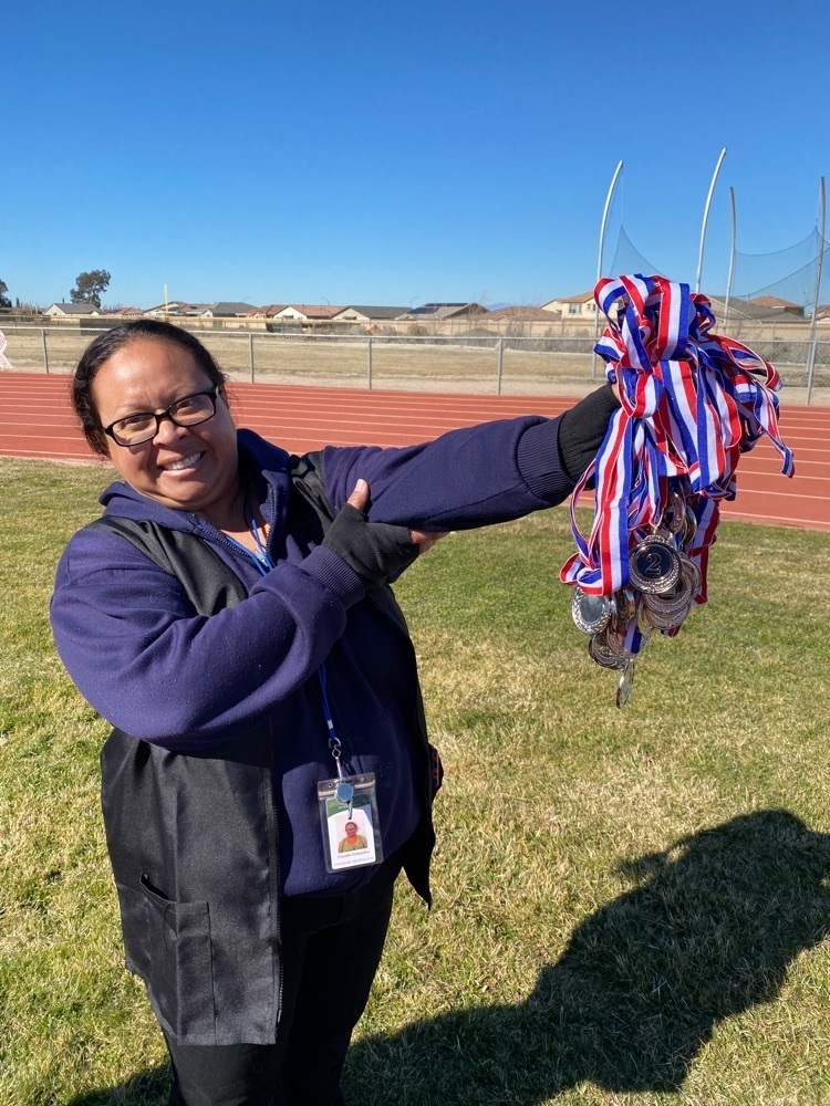 Staff member with medals for students 